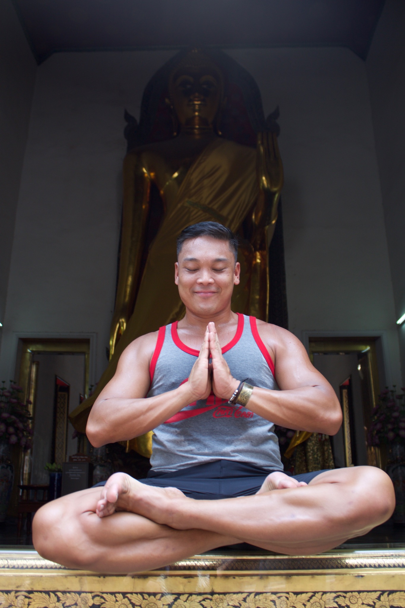 Aaron Miko seated cross-legged with hands together