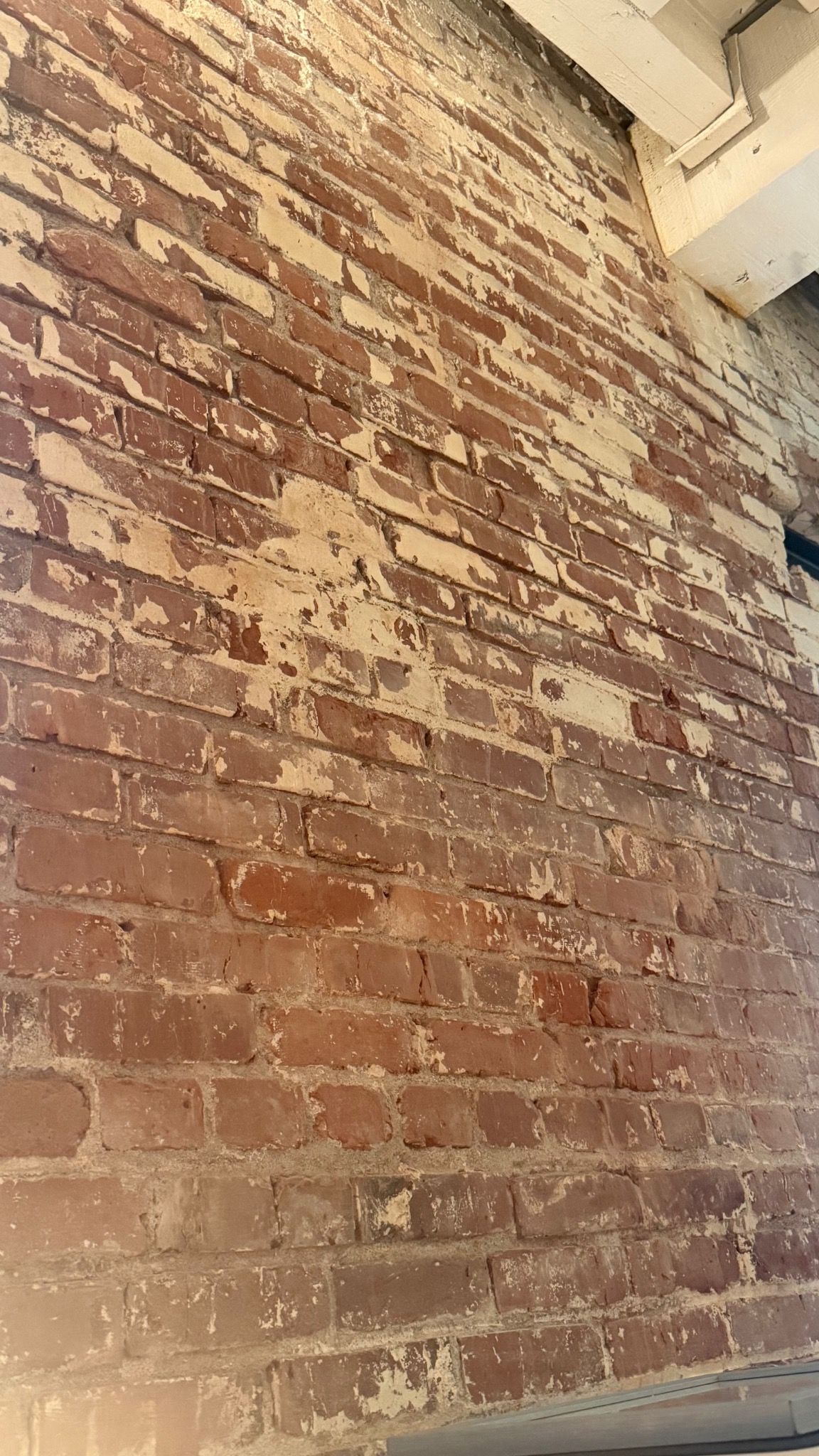 The worn exposed brick wall in Chris and Aaron Miko’s home, presented with a warm nighttime treatment